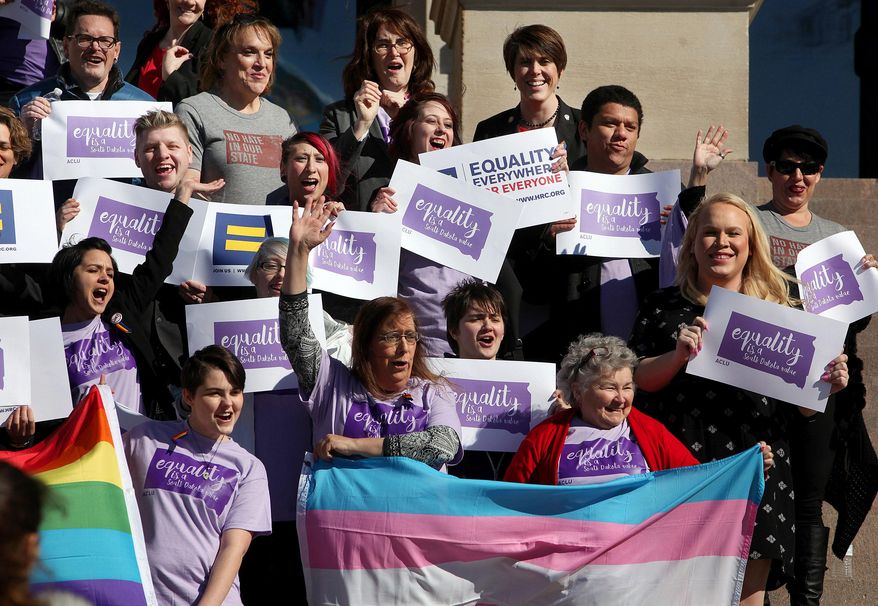 Representatives from the Center for Equality, American Civil Liberties Union of South Dakota, LGBT supporters and members of the Human Rights Campaign stand on the front steps of the State Capitol to honor Trans Kids Support Visibility Day in Pierre, S.D. on Tuesday, Feb. 23, 2016. Gov. Dennis Daugaard heard from several transgender people during a meeting Tuesday at the Capitol, where advocates gathered to urge the governor to veto a bill that would require students to use bathrooms and locker rooms that match their sex at birth. (Jay Pickthorn /The Argus Leader via AP) NO SALES; MANDATORY CREDIT