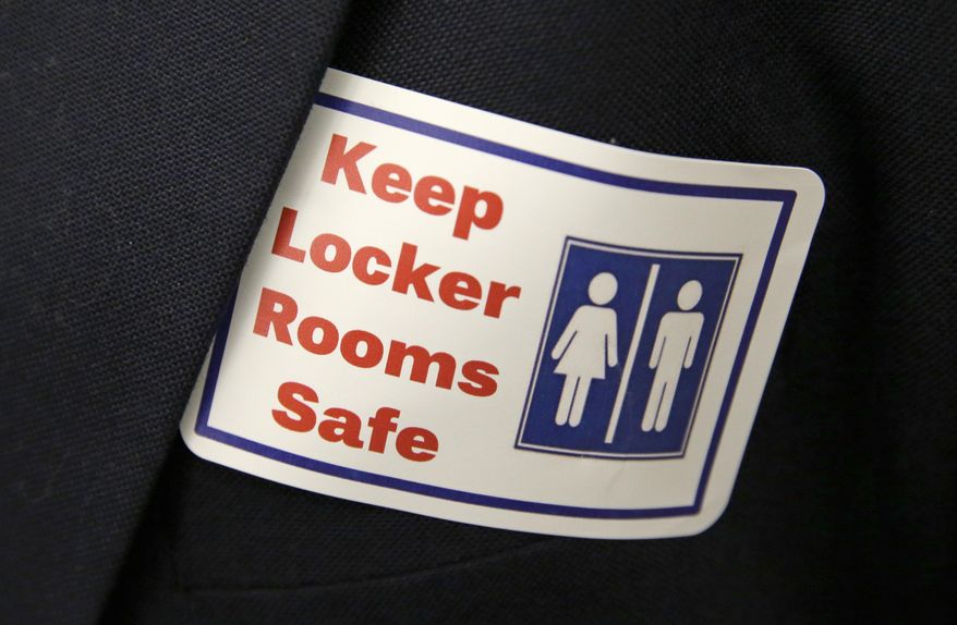 In this Jan. 27, 2016, file photo, a sticker that reads, "Keep Locker Rooms Safe," is worn by a person supporting a bill that would eliminate Washington's new rule allowing transgender people use gender-segregated bathrooms and locker rooms in public buildings consistent with their gender identity, at the Capitol in Olympia, Wash. (AP Photo/Ted S. Warren, File)