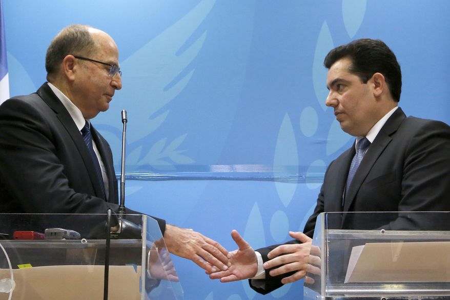 Israeli Defense minister Moshe Yaalon, left, and his Cypriot counterpart Fotis Fotiou shake hands during their statements to the media after their meeting at the Defense ministry in capital Nicosia, Cyprus, Wednesday, Feb. 24, 2016. Israel’s defense minister is accusing Iran of building an international terror network that includes ‘sleeper cells’ stockpiling arms, intelligence and operatives that are ready to strike on command in places including Europe and the U.S. Yaalon says Iran aims to destabilize the Middle East and other parts of the world and is training, funding and arming “emissaries” to spread revolution. He also says Tehran is the anchor of a “dangerous axis” that includes Baghdad, Damascus, Beirut, Saana and other cities in the region. (AP Photo/Petros Karadjias)