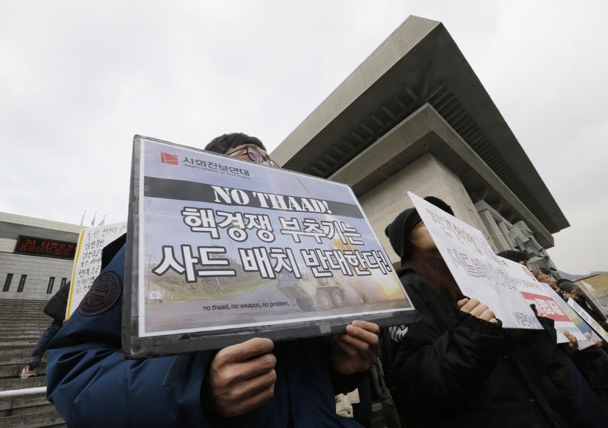 South Korean protesters shout slogans during a rally to oppose the possible deployment of the United States' advanced defense system THAAD, or Terminal High-Altitude Area Defense, on Korea Peninsula, in Seoul, South Korea, Thursday, Feb. 25, 2016. The United States and China have reached agreement on a U.N. resolution that would impose tougher sanctions on North Korea as punishment for its latest nuclear test and rocket launch, U.N. diplomats said Wednesday. The signs read " Oppose deployment of the THAAD." (AP Photo/Ahn Young-joon)