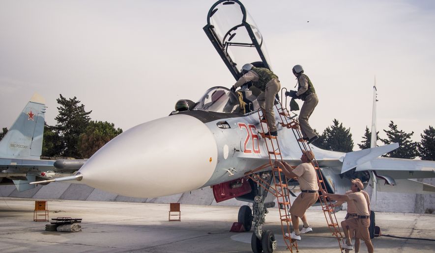 FILE - In this file photo taken on Thursday, Oct.  22, 2015, Russian air force pilots assisted by ground crew climb into their fighter jet at Hemeimeem airbase, Syria. (AP Photo/Vladimir Isachenkov, File)