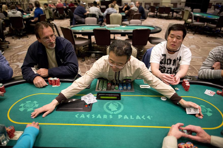 FILE - In this Feb. 27, 2013 file photo, dealer Han Kim, center, gathers up chips after a hand of Texas Hold 'em at a poker room in Caesar's Palace in Las Vegas. Nevada regulators say casinos in the state kept about 2.9 percent less of the money gambled in January, compared with a year earlier. The Nevada Gaming Control Board reported Friday, Feb. 26, that casinos won just over $925 million last month, down from almost $953 million in the first month of 2015. (AP Photo/Julie Jacobson, File)