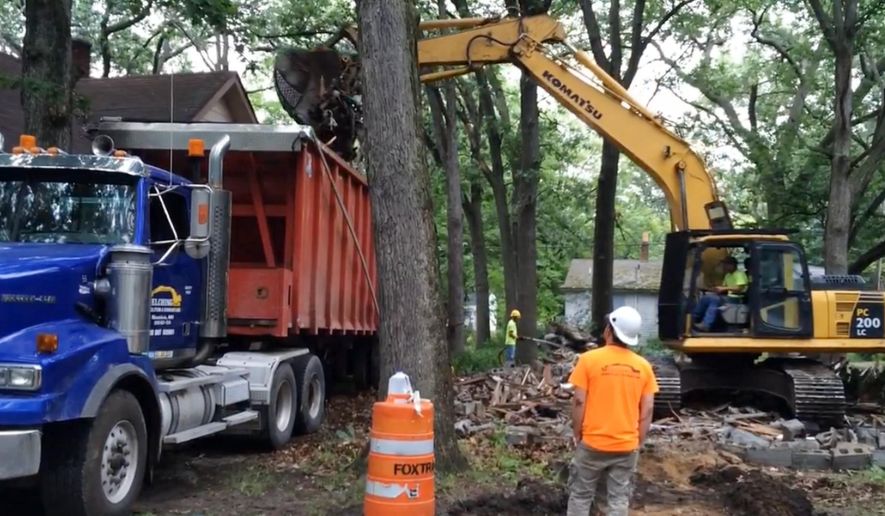 ADVANCE FOR SUNDAY, FEB. 28 AND THEREAFTER- FILE- In a July 13, 2015 frame grab from video, crews tear down boarded-up home in Muskegon Heights, Mich. The Muskegon County Land Bank and the city of Muskegon Heights tore down about 60 abandoned homes during 2015 to fight blight. Muskegon County Land Bank Director Tim Burgess said most of the homes demolished were in the west half of the city. (Stephen Kloosterman/The Muskegon Chronicle, MLive.com via AP)