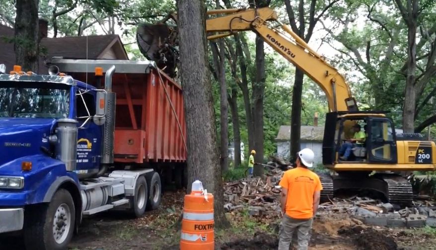 ADVANCE FOR SUNDAY, FEB. 28 AND THEREAFTER- FILE- In a July 13, 2015 frame grab from video, crews tear down boarded-up home in Muskegon Heights, Mich. The Muskegon County Land Bank and the city of Muskegon Heights tore down about 60 abandoned homes during 2015 to fight blight. Muskegon County Land Bank Director Tim Burgess said most of the homes demolished were in the west half of the city. (Stephen Kloosterman/The Muskegon Chronicle, MLive.com via AP)