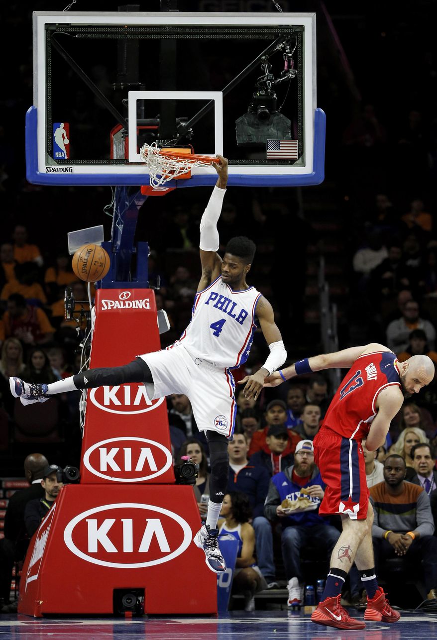 Philadelphia 76ers' Nerlens Noel, left, dunks past Washington Wizards' Marcin Gortat during the first half of an NBA basketball game Friday, Feb. 26, 2016, in Philadelphia. (AP Photo/Matt Slocum)