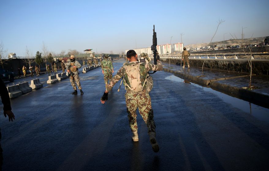 An Afghan National Army soldier walks at the site of a suicide attack near the Defense Ministry compound, in Kabul, Afghanistan, Saturday, Feb. 27, 2016. A suicide bomber struck Saturday in Kabul, killing at least a dozen people near the Defense Ministry compound, said Gen. Abdul Rahman Rahimi, the Kabul police chief. (AP Photos/Massoud Hossaini)