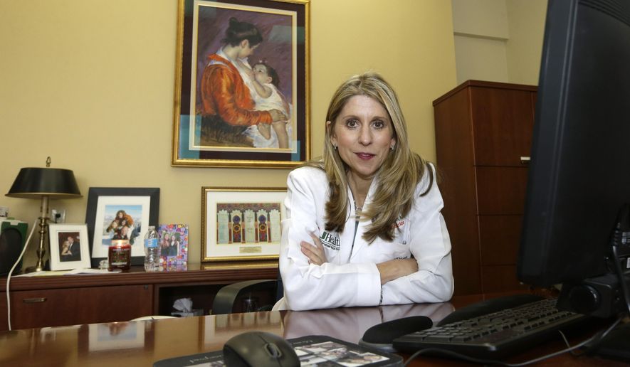 In this photo taken Wednesday, Feb. 10, 2016, Dr. Judy Schaechter poses for a photo at her office at the University of Miami, Miller School of Medicine, in Miami. As a pediatrician, Dr. Schaechter makes it a point to ask parents of young children whether they have a backyard pool and, if so, whether they have safety measures such as a fence. Schaechter is free to discuss swimming pools, but she faces sharp limits under a 2011 Florida law in what she can say about guns in the home. (AP Photo/Alan Diaz)