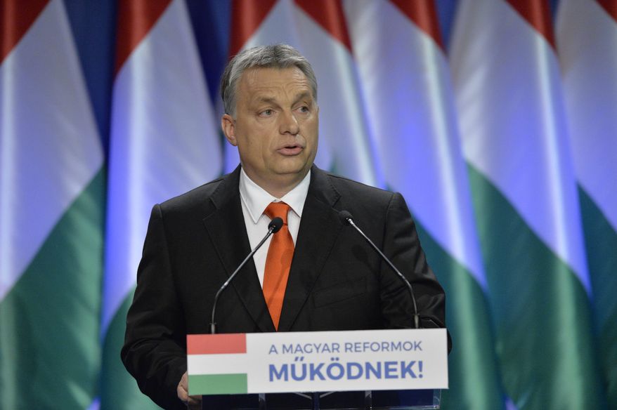 Hungarian Prime Minister Viktor Orban delivers his annual 'State of Hungary' speech in Budapest, Hungary, Sunday, February 28, 2016. Orban says he has ordered the interior and defense ministers to begin preparing the construction of defenses on the border with Romania to prevent migrants from entering. He also said that the European Union bureaucrats and Germany’s welcoming culture are to blame for the migrant crisis on the continent. The inscription reads: "Hungarian Reforms Are Working". (Szilard Koszticsak/MTI via AP)