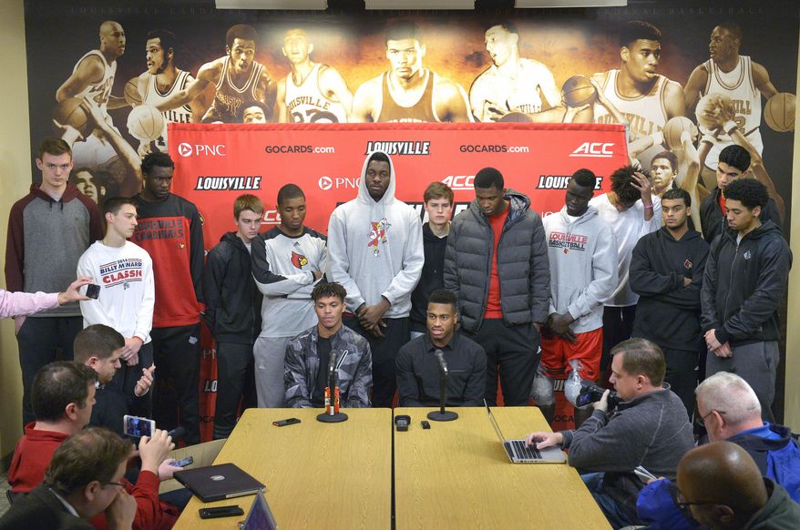 FILE - In this Feb. 5, 2016, file photo, surrounded by teammates, Louisville graduate students Damion Lee, seated left, and Trey Lewis meet with reporters during a press conference, in Louisville Ky. Louisville's decision to sit out the postseason because of recruiting violations dashed the dreams of Trey Lewis and Damion Lee to play in the NCAA Tournament. But they enter Tuesday night's, March 1, 2016, home finale consoled by helping the Cardinals achieve success nobody envisioned when they transferred there. (AP Photo/Timothy D. Easley, File)
