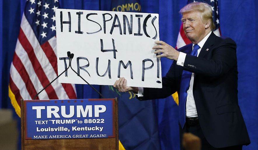 Republican presidential candidate Donald Trump holds up a sign he borrowed from a spectator during a rally Tuesday, March 1, 2016, in Louisville, Ky. (AP Photo/John Bazemore)