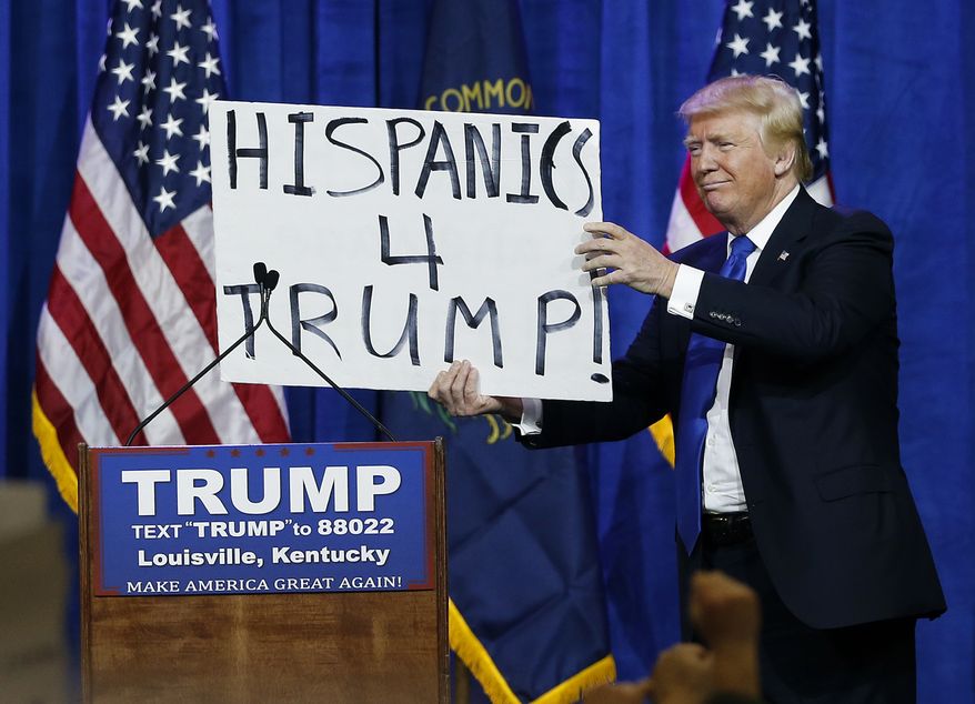 Republican presidential candidate Donald Trump holds up a sign he borrowed from a spectator during a rally Tuesday, March 1, 2016, in Louisville, Ky. (AP Photo/John Bazemore)