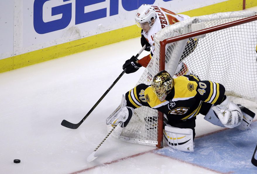 Boston Bruins goalie Tuukka Rask (40) reaches for the puck to defend against Calgary Flames left wing Micheal Ferland (79) in the first period of an NHL hockey game, Tuesday, March 1, 2016, in Boston. (AP Photo/Elise Amendola)