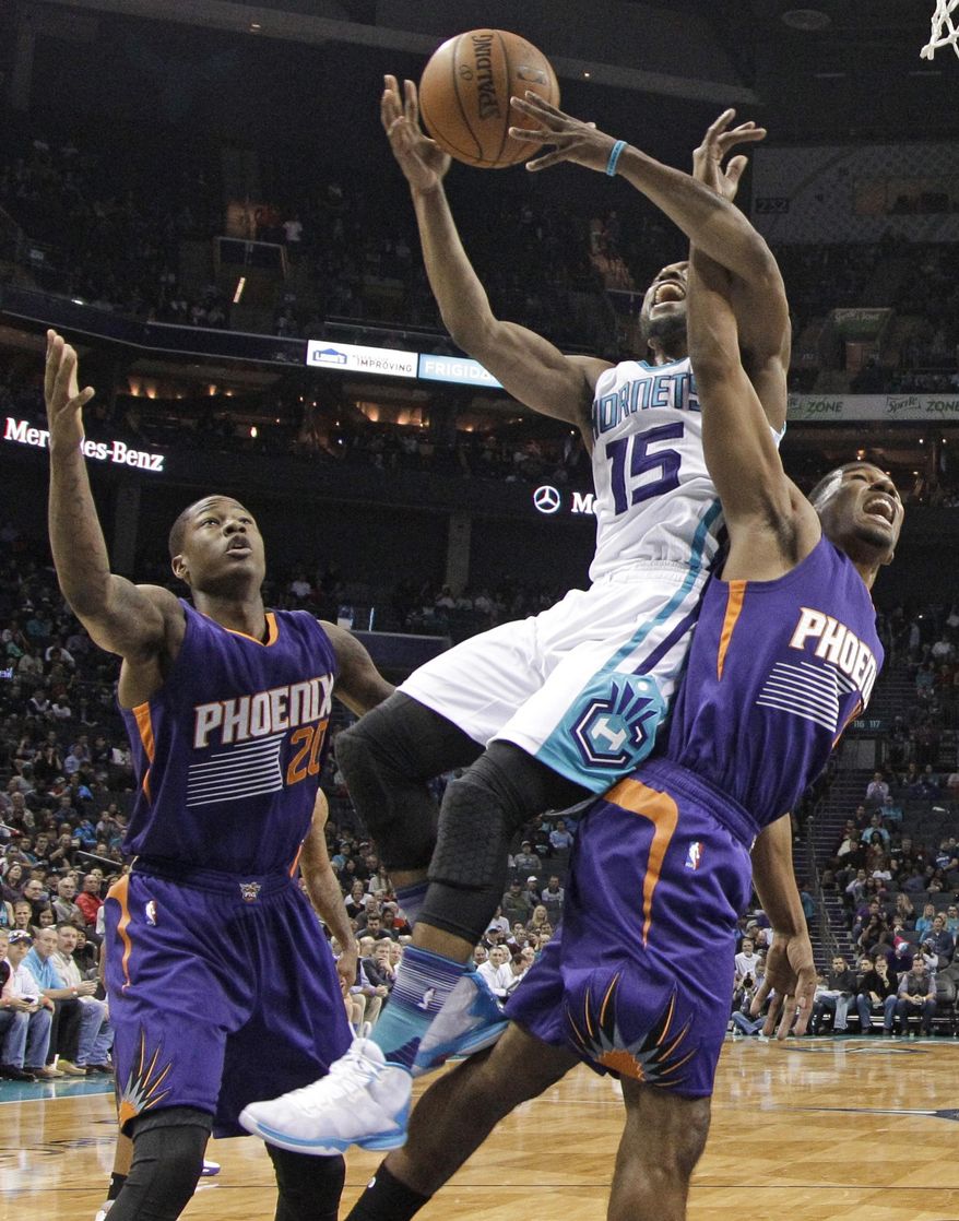 Charlotte Hornets&#39; Kemba Walker (15) is fouled as he drives between Phoenix Suns&#39; Archie Goodwin (20) and Ronnie Price during the first half of an NBA basketball game in Charlotte, N.C., Tuesday, March 1, 2016. (AP Photo/Chuck Burton)