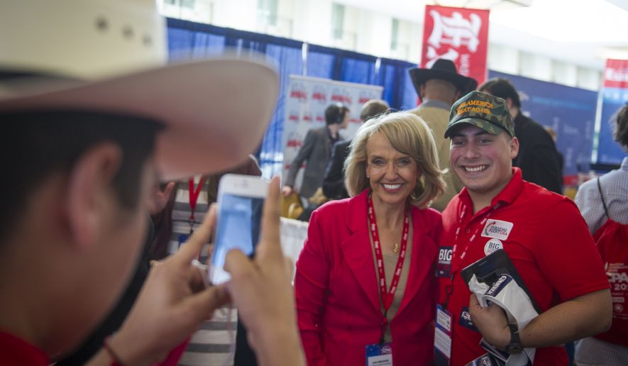 Former Arizona Gov. Jan Brewer poses with Justin Carrizales with the Leadership Institute on the first day of the American Conservative Union CPAC 2016 at the Gaylord National Resort and Convention Center in National Harbor, Md., Thursday, March 3, 2016. (Photo Rod Lamkey Jr.)