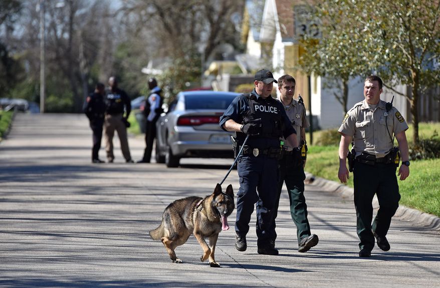 Vicksburg police and Warren County sheriff's deputies search Wednesday in a Vicksburg neighborhood, Miss., for escaped inmate Rafael McCloud, who is a suspect in a capital murder, on Wednesday, March 2, 2016. (Justin Sellers/The Clarion-Ledger via AP) MANDATORY CREDIT