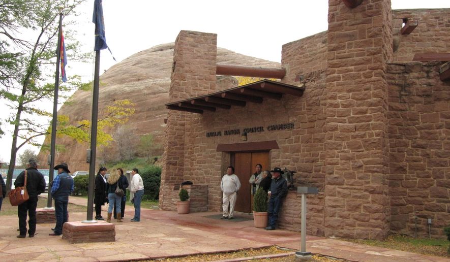 FILE - In this Oct. 21, 2010 photo, people gather outside the Navajo Nation Council chambers in Window Rock, Ariz. More than three-fourths of the 88-member Navajo Nation Council has been charged in an investigation into the use of discretionary funds. A long-running saga stemming from allegations that Navajo tribal officials schemed to give money to family members is drawing to a close. (AP Photo/Felicia Fonseca)