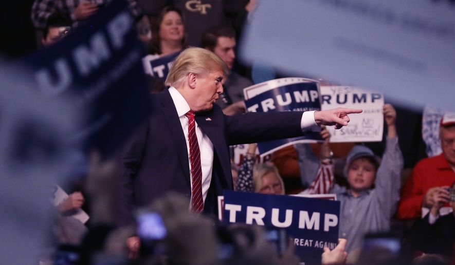 Republican presidential candidate Donald Trump points out a protester during a rally at Macomb Community College, Friday, March 4, 2016, in Warren, Mich. (AP Photo/Carlos Osorio)