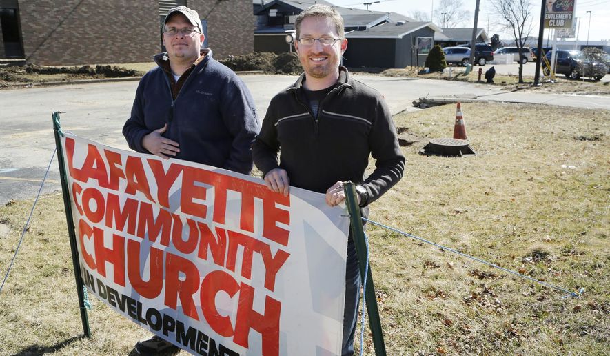 Associate pastor Billy Hardy, left, and pastor Jeff Mikels stand outside the new Lafayette Community Church in Lafayette, Ind., Wednesday, March 2, 2016, The church will be next door neighbors with Filly's Gentlemens Club, background. (John Terhune/Journal & Courier via AP)