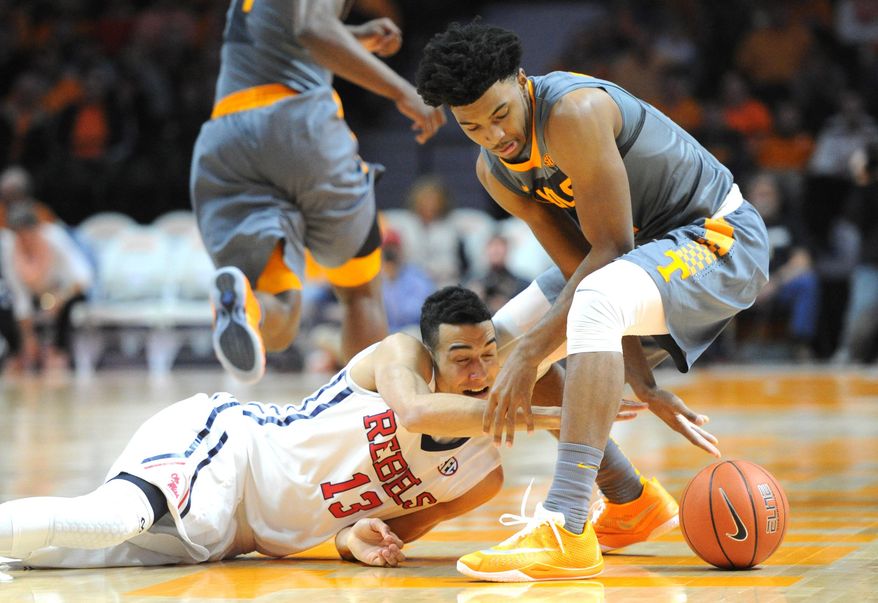 Mississippi forward Anthony Perez (13) and Tennessee guard Shembari Phillips tangle for a loose ball during the first half of an NCAA college basketball game, Saturday, March 5, 2016, in Knoxville, Tenn. (Adam Lau/Knoxville News Sentinel via AP) MANDATORY CREDIT