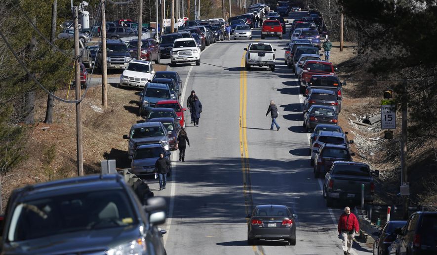 Voters walk to a Republican caucus, Saturday, March 5, 2016, in Chelsea, Maine. A large turnout forced some voters to park more than a half-mile away from the Kennebec County caucus location at the Chelsea Elementary School. (AP Photo/Robert F. Bukaty)