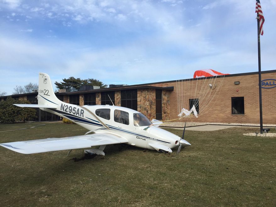 In this photo provided by Anthony Rappa, an aircraft rests on a grassy area adjacent to a factory after making an emergency landing in Happauge, N.Y., Saturday, March 5, 2016. The passengers, a father and daughter, returning from visiting a college in Rhode Island, suffered only minor injuries, fire officials said. (Anthony Rappa via AP) MANDATORY CREDIT