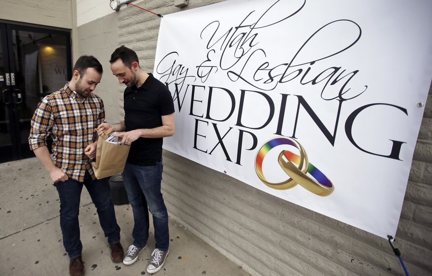 Engaged couple Will Bladh, left, and Jason Langlois look at their gift bag at a gay and lesbian wedding expo aimed at connecting same-sex couples with businesses who won't refuse to work on gay weddings Sunday, March 6, 2016, in Salt Lake City. That's a common occurrence in a state where florists, bakers and photographers have a legal right to refuse to serve a gay couple. (AP Photo/Rick Bowmer)