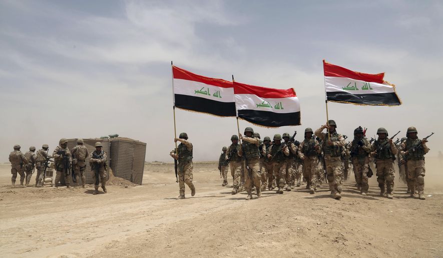 U.S. soldiers (left) participate in a training mission with Iraqi army soldiers outside Baghdad on May 27, 2015. (Associated Press) **FILE**