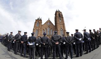 Police stand outside Sacred Heart Church for the funeral of Prince William County, Va., Police Officer Ashley Guindon, Monday, March 7, 2016, in Springfield, Mass. Guindon, 28, a Springfield native, was killed during her first shift on the job Feb. 27 while responding to a domestic dispute in Woodbridge, Va. (AP Photo/Elise Amendola)