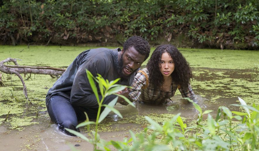 This image released by WGN shows Aldis Hodge, left, and Jurnee Smollett-Bell in a scene from "Underground," a new drama series premiering on WGN America on Wednesday at 10 p.m. EDT. (Skip Bolen/Sony Pictures Television via AP)