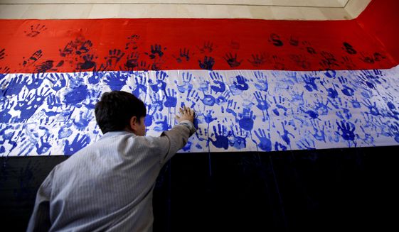 A boy gets his hand print on a Yemeni flag during a gathering by held Shiite rebels, known as Houthis, against Saudi-led airstrikes in Sanaa, Yemen, Wednesday, March 9, 2016. (AP Photo/Hani Mohammed)