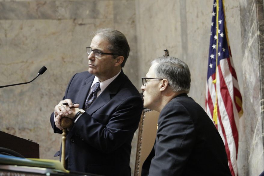 Gov. Jay Inslee, right, talks with Lt. Gov. Brad Owen in the Senate chamber on the last day of the regularly scheduled 60-day legislative session, Thursday, March 10, 2016, in Olympia, Wash. Lawmakers face a special session after not finishing a supplemental budget on time. (AP Photo/Rachel La Corte)