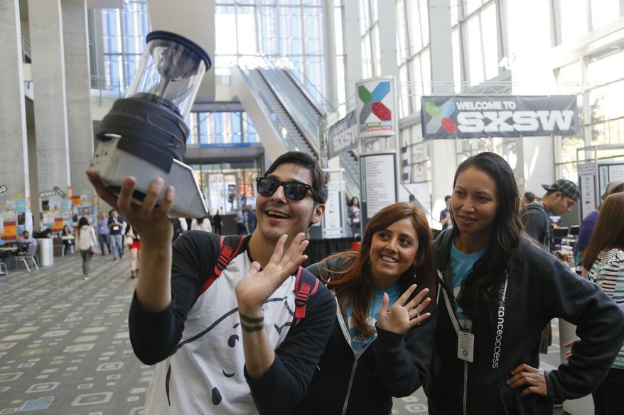FILE - In this Saturday, March 14, 2015, file photo, JJ Castillo, from left, Vanessa Cottingham, and Pamela Ledbetter, wave at a Koceto Jo prototype 360-degree view video camera during the SXSW Interactive Festival in Austin, Texas. At South by Southwest Interactive, an annual tech festival dubbed “Spring Break for nerds,” eyes are on virtual reality, online privacy and, of course, the latest hot apps. The five-day festival kicks off Friday, March 11, 2016, in Austin, Texas. (AP Photo/Jack Plunkett, File)