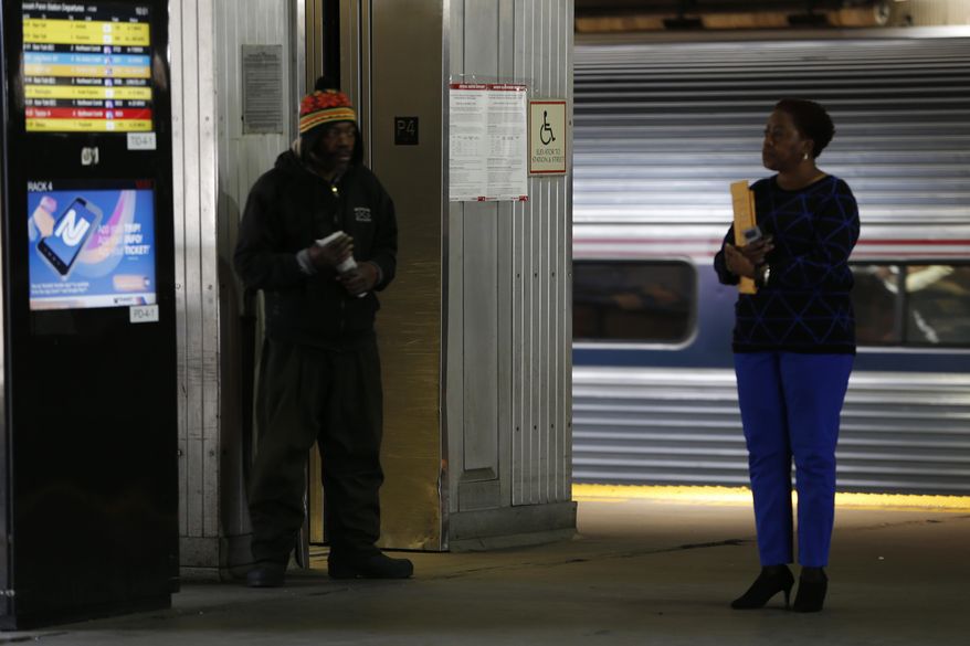 A sign, center, alerts commuters of a possible strike by the NJ Transit rail workers as commuters stand on the platform at Newark Penn Station, Friday, March 11, 2016, in Newark, N.J. More than 100,000 commuters use NJ Transit to get into New York City, and the transit agency says its contingency plan using extra buses will only be able to accommodate about 40,000 riders. NJ Transit has estimated that a one-hour commute by train will more than double. (AP Photo/Julio Cortez)