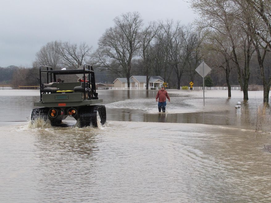 James Norman walks through flood waters to meet with a rescue crew in an amphibious vehicle on Friday, March 11, 2016 in unincorporated Shelby County, Tenn. (AP Photo/Adrian Sainz).
