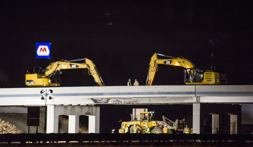 Demolition crews work to remove a damaged overpass on 8 Mile Road bridge over U.S. Highway 23 near Whitmore Lake, Mich., late Thursday, March 10, 2016 after a semi-truck hit the bridge earlier in the morning. (Allison Farrand/The Ann Arbor News via AP)