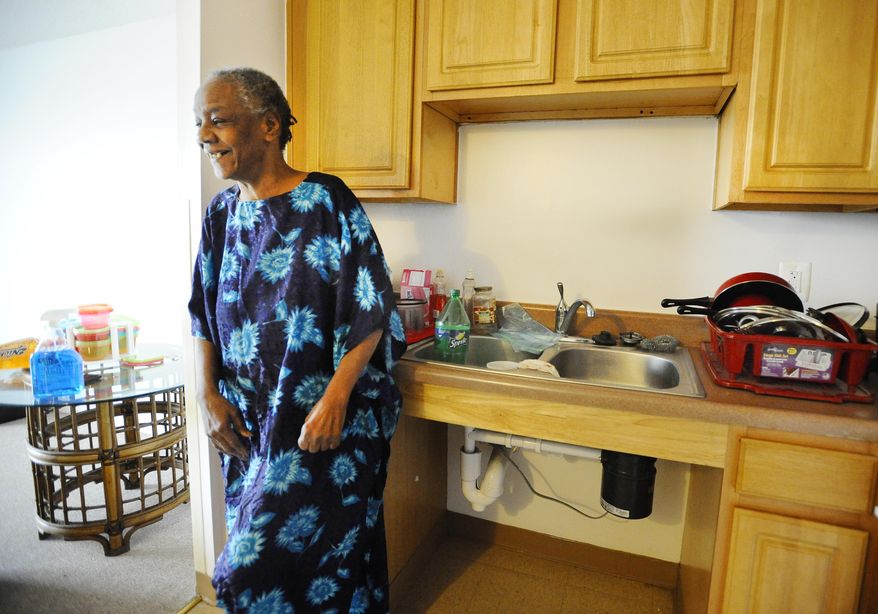 In this March 9, 2016 photo, Fayette Coleman stands in the kitchen of her new home, an apartment near the medical center area in Detroit. Coleman, 66, was previously renting one of the 6,000 Detroit homes that never had water service restored after a massive citywide shut-off campaign. (Daniel Mears/Detroit News via AP)