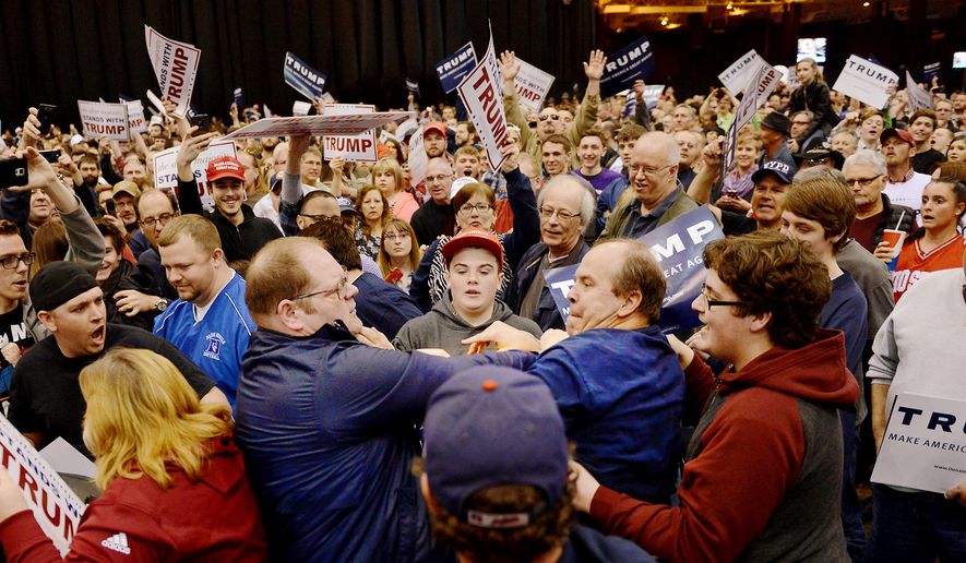 A protester, center left, and a Trump supporter, center right, scuffle during a rally for Republican presidential candidate Donald Trump Saturday, March, 12, 2016, held at the I-X Arena in Cleveland, Ohio. (Michael Henninger/Pittsburgh Post-Gazette via AP)