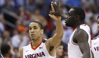 Virginia guard Malcolm Brogdon (15) gives a high-five to guard Marial Shayok (4) during the second half of an NCAA college basketball game against Miami in the Atlantic Coast Conference  men&#39;stournament, Friday, March 11, 2016, in Washington. Virginia defeated Miami 73-68. (AP Photo/Steve Helber)