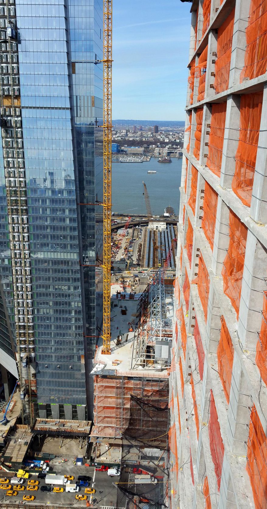 This March 3, 2016, photo, from a high-rise under construction shows the view from the narrow walkway crane operators use to reach their glass control cab, on New York's west side. All around New York City, mammoth cranes fill the city skyline, erecting dozens of skyscrapers that are part of the city's current building boom. At right is Brookfield Property Group's Manhattan West project where orange netting is all that separates workers from a 50 floor drop. (AP Photo/Verena Dobnik)