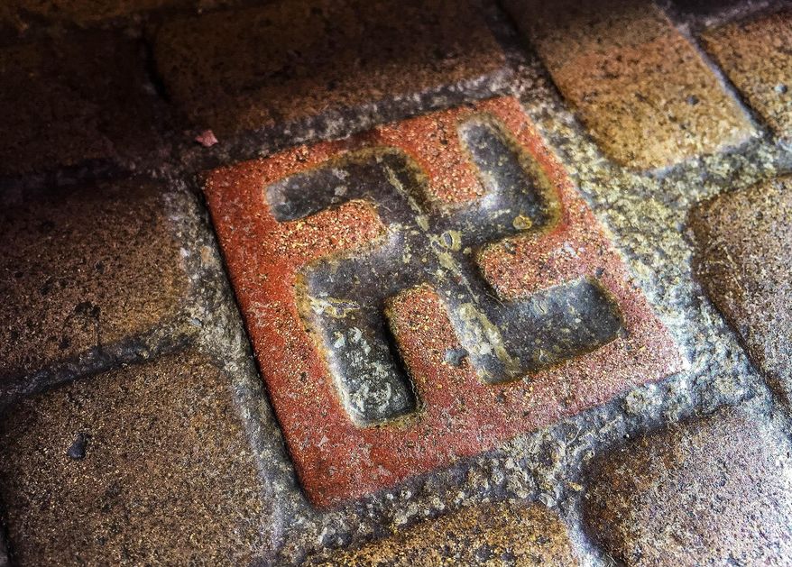 ADVANCE FOR WEEKEND EDITIONS - This March 3, 2016 photo shows one of about 60 floor tiles emblazoned with swastika-style crosses in the entrance to the Longview Community Church in Longview, Wash. A Longview church established in 1925 bears tiles with symbols that were once seen as a sign of good fortune, but are now more closely associated with terror. (Marissa Luck/The Daily News via AP) MANDATORY CREDIT