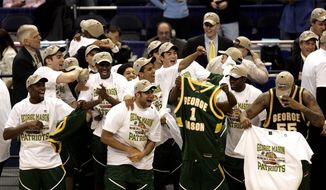 George Mason players celebrate their 86-84 overtime victory over Connecticut during the fourth round game of the NCAA basketball tournament in Washington, Sunday, March 26, 2006. (AP Photo/Susan Walsh)