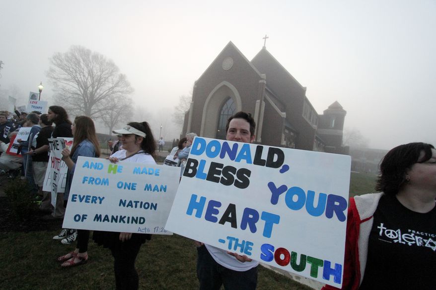 Protestor Cory Gryder holds up a sign during a Donald Trump rally in Hickory, N. C., held at Lenior-Ryhne University, Monday, March 14, 2016. (AP Photo/Ben Earp)