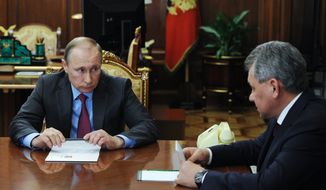 Russian President Vladimir Putin, left, listens to Russian Defense Minister Sergey Shoygu during their meeting in the Kremlin in Moscow, Russia, Monday, March 14, 2016. Russian President Vladimir Putin has ordered the start of the pullout of the Russian military from Syria starting Tuesday. (Mikhail Klimentyev, Sputnik, Kremlin Pool Photo via AP)