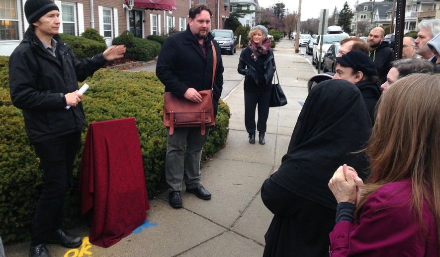 Fans of H.P. Lovecraft's writings gather to unveil a marker near where Lovecraft's childhood house once stood, on the 79th anniversary of fantasy horror writer's death, in Providence, R.I., Tuesday, March 15, 2016. (AP Photo/Jennifer McDermott)