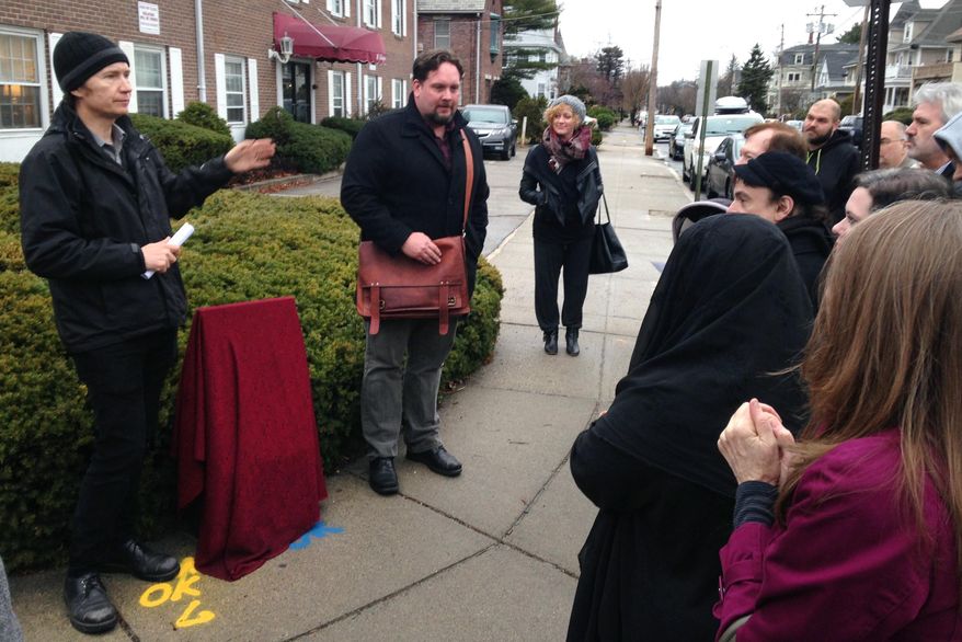 Fans of H.P. Lovecraft's writings gather to unveil a marker near where Lovecraft's childhood house once stood, on the 79th anniversary of fantasy horror writer's death, in Providence, R.I., Tuesday, March 15, 2016. (AP Photo/Jennifer McDermott)