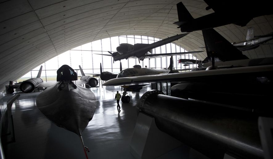 A man walks through aircrafts and other items on display during a media event to mark the reopening of the American Air Museum after it underwent a major redevelopment, at the Imperial War Museum of aviation in Duxford, England, Wednesday, March 16, 2016. The transformed American Air Museum opens to the public from Saturday March 19 and tells the story of Anglo-American collaboration in 20th and 21st century conflict as seen through the eyes of the people linked with the aircraft and objects on display. (AP Photo/Matt Dunham)