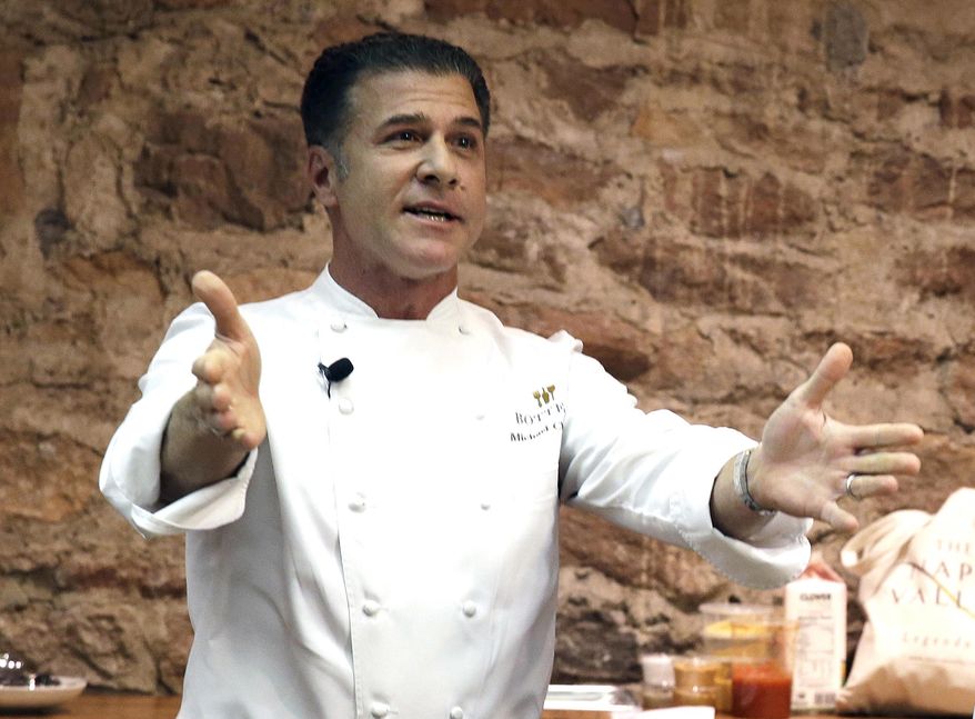 This Nov. 23, 2013, file photo shows Chef Michael Chiarello, of Bottega restaurant gestures before the start of an East meets West cooking battle in St. Helena, Calif. (AP Photo/Eric Risberg, File)