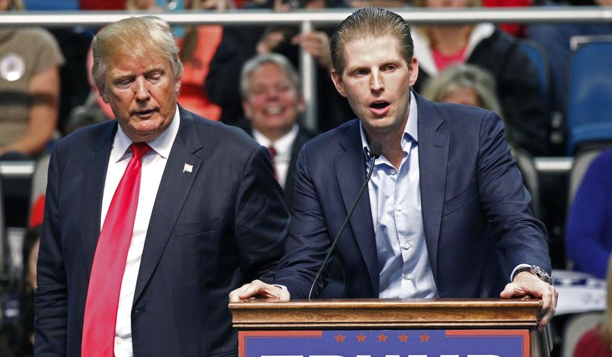 Republican presidential candidate Donald Trump, left, listens as his son Eric Trump speaks during a rally in Biloxi, Miss., in this Jan. 2, 2016, file photo. (AP Photo/Rogelio V. Solis) ** FILE **