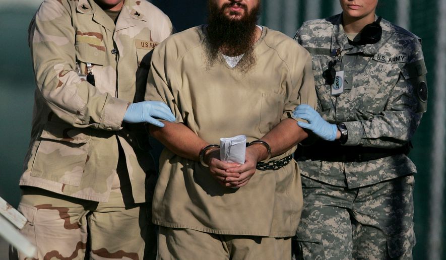 In this Dec. 6, 2006, file photo, reviewed by a U.S. Department of Defense official, a shackled detainee is transported away from his annual Administrative Review Board hearing with U.S. officials, in Camp Delta detention center at the Guantanamo Bay U.S. Naval Base in Cuba. (AP Photo/Brennan Llinsley, File)