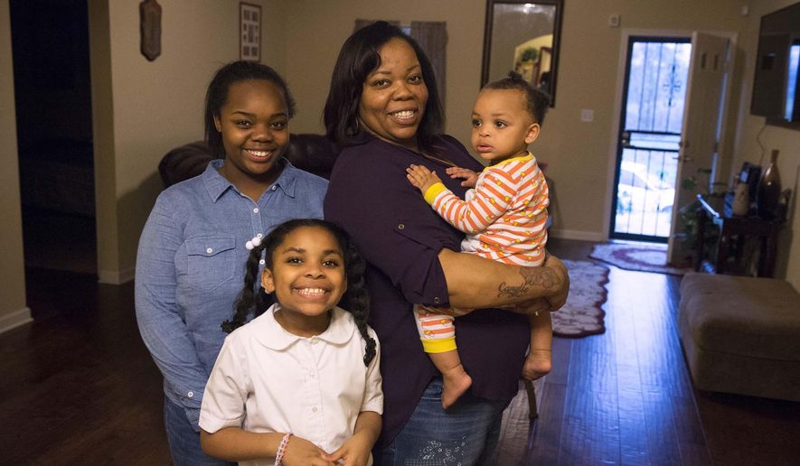 In a March 10, 2016 photo, Tamika Walker, second from right, poses with her daughters, from left, Tamia, 17, Camryn, 8, and Camylle, 1, in their home in the Wolf River Bluffs neighborhood in Memphis, Tenn. After 10 years of discipline to clear up $25,000 in credit card and car-loan debts as well as a credit history that included bankruptcy, Tamika and her husband Clarence Walker bought a house. For the same amount they had been paying in rent, Tamika said. (Brandon Dill/Special to The Commercial Appeal)